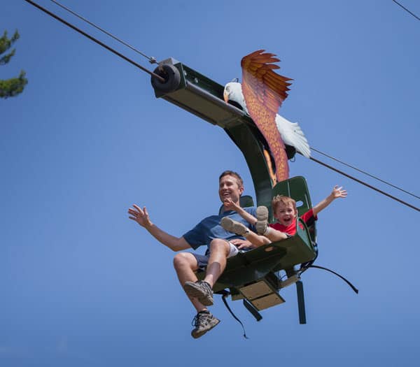 father and son on soaring eagle seated zip line