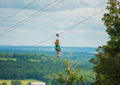 Woman on the dual zip line overlooking a valley