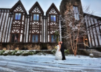 married couple standing outside of peek n peak resort in winter snow