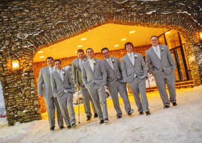 groomsmen in gray under lit archway