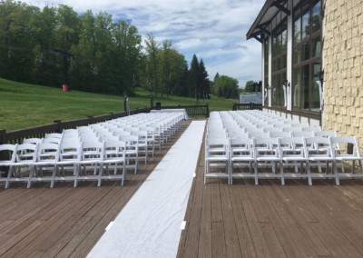 looking down the aisle towards chairs at outdoor wedding ceremony