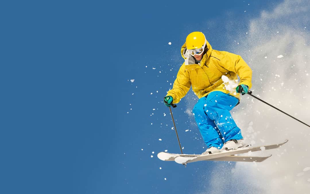 person in bright outfit doing cool ski jump