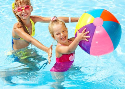 2 girls in pool having fun with beach ball