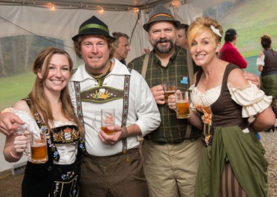 4 adults drinking beer dressed in traditional German garb