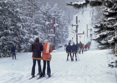 old historic photo of many people skiing at peek n peak resort